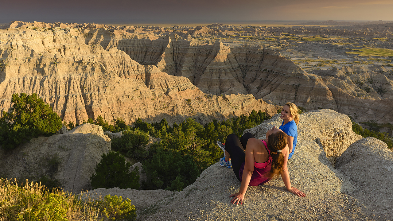 Two hikers enjoying the view of Badlands National Park